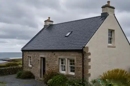 Slate roof and sandstone property under an overcast sky